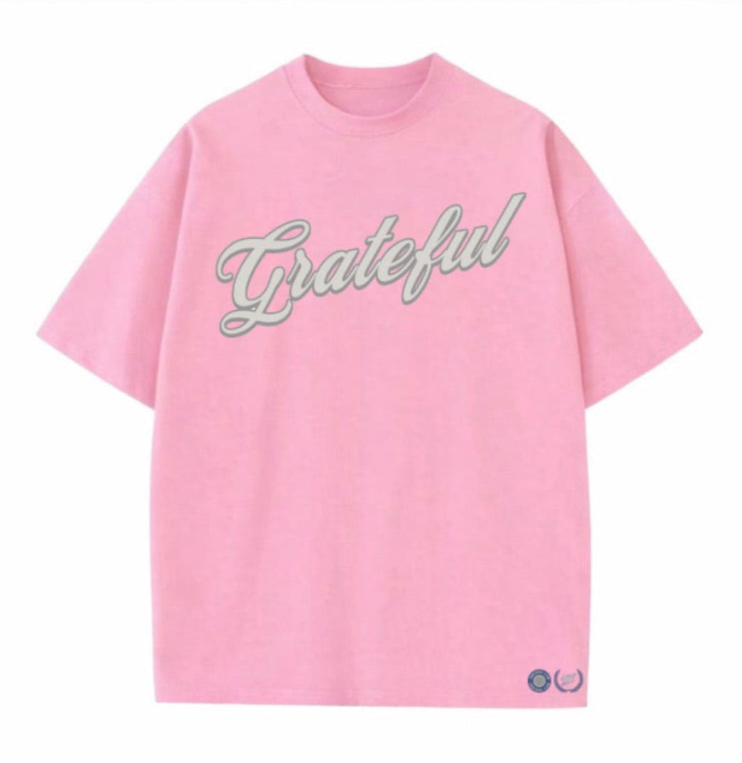 Pink t-shirt with 'Grateful' text on a white background