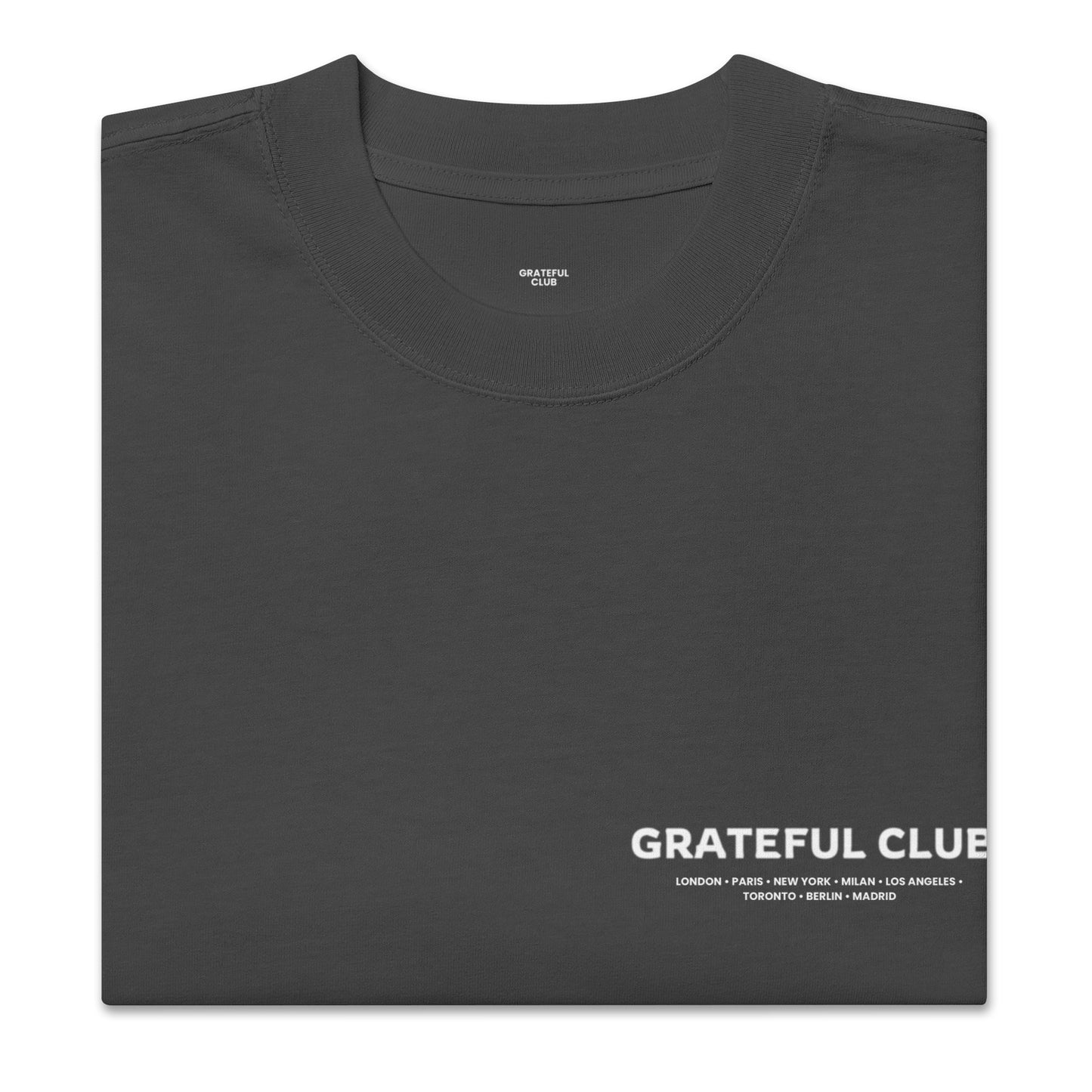 Folded black t-shirt with 'Grateful Club' text on a white background