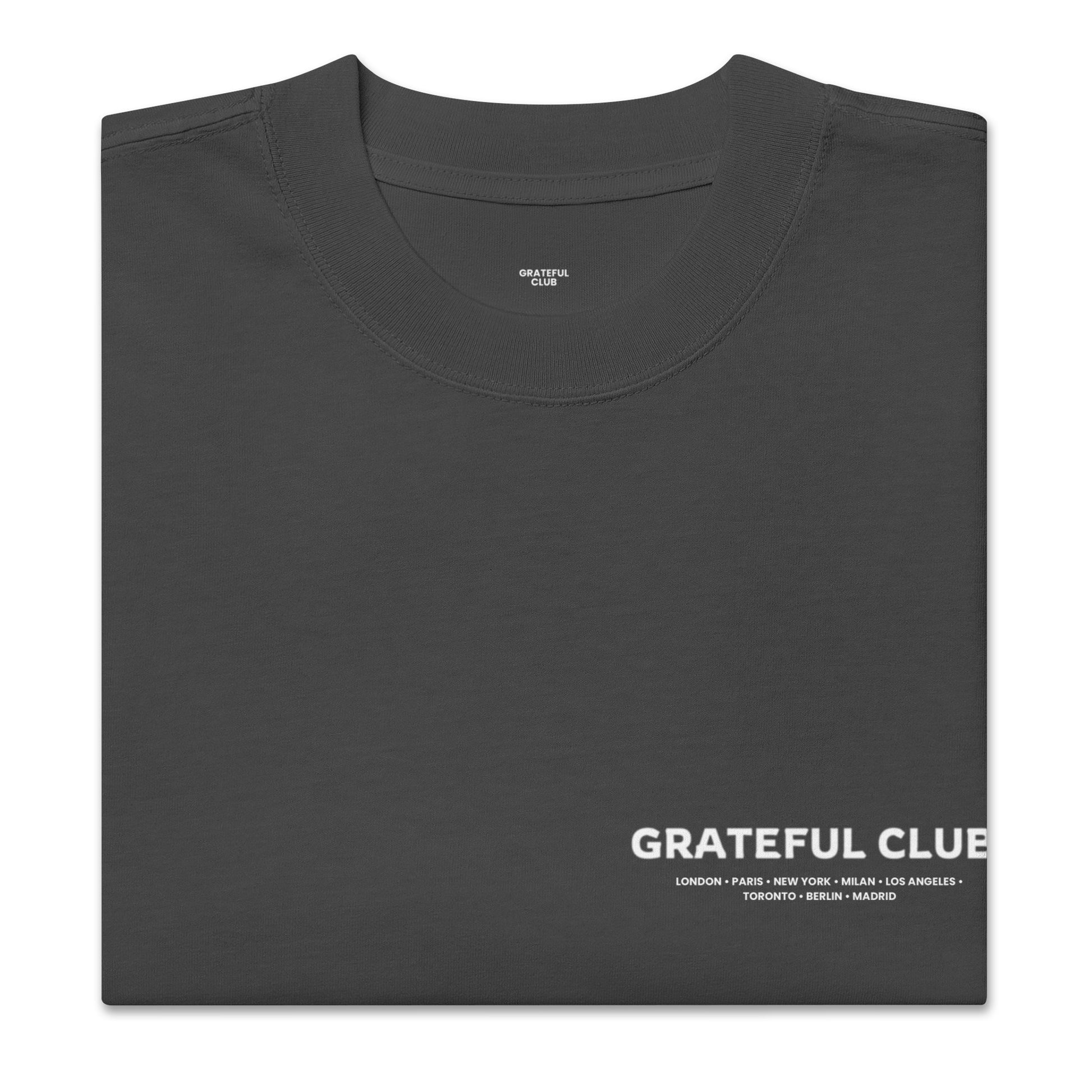 Folded black t-shirt with 'Grateful Club' text on a white background